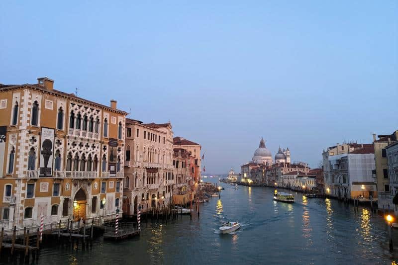 Blick über den Canal Grande auf die Kirche Santa Maria della Salute in Venedig bei einsetzender Abenddämmerung