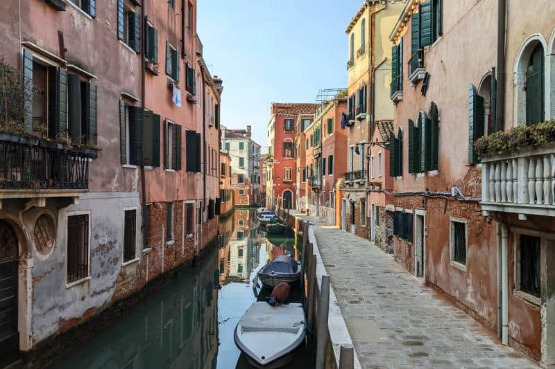 Blick auf einen Kanal in Cannaregio mit Motorbooten und Häusern mit grünen Fensterläden
