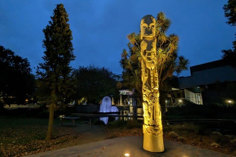 Beleuchtete, geschnitzte Säule mit Maori-Motiven in Christchurch, Neuseeland