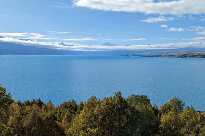 Das blaue Wasser des Lake Pukaki mit den Gipfeln des Aoraki/Mount Cook und anderen Bergen im Hintergrund