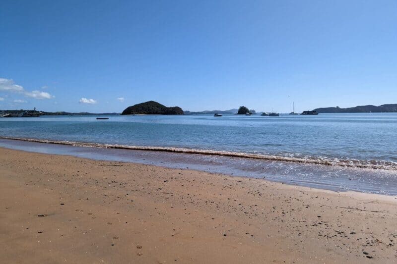Strand in Paihia mit kleinen Inseln im Hintergrund