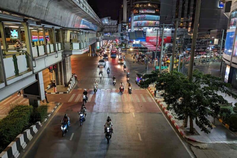 Motorroller auf einer nächtlichen belebten Straße in Bangkok