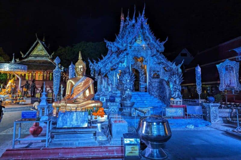 Der silbrig-blau leuchtende Wat Sri Suphan mit einer goldenen Buddha-Statue in Chiang Mai bei Nacht