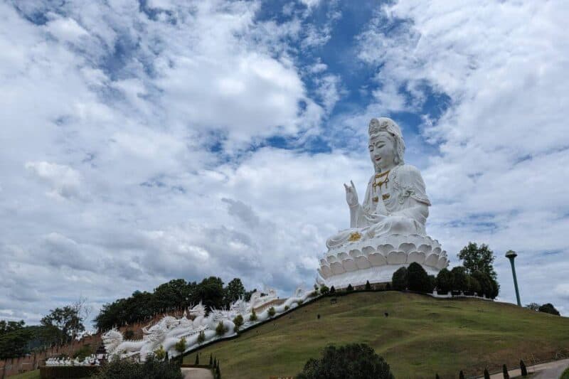 Weiße Statue der Göttin Guanyin auf einem grünen Hügel im Wat Huay Pla Klang in Chiang Rai