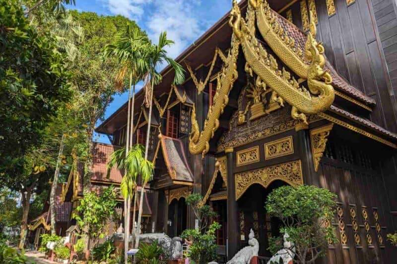 Die mit dunklem Holz und Gold verzierte Fassade des Wat Phra Kaeo in Chiang Mai