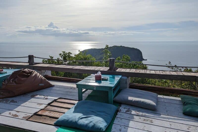 Sitzkissen und ein kleiner Tisch mit Aussicht über das Meer und eine vorgelagerte Insel im 420 Club auf Koh Phangan 