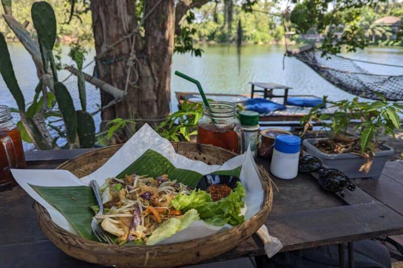 Thailändisches Nudelgericht vor der Kulisse eines Teichs mit Hängematte auf Koh Phangan
