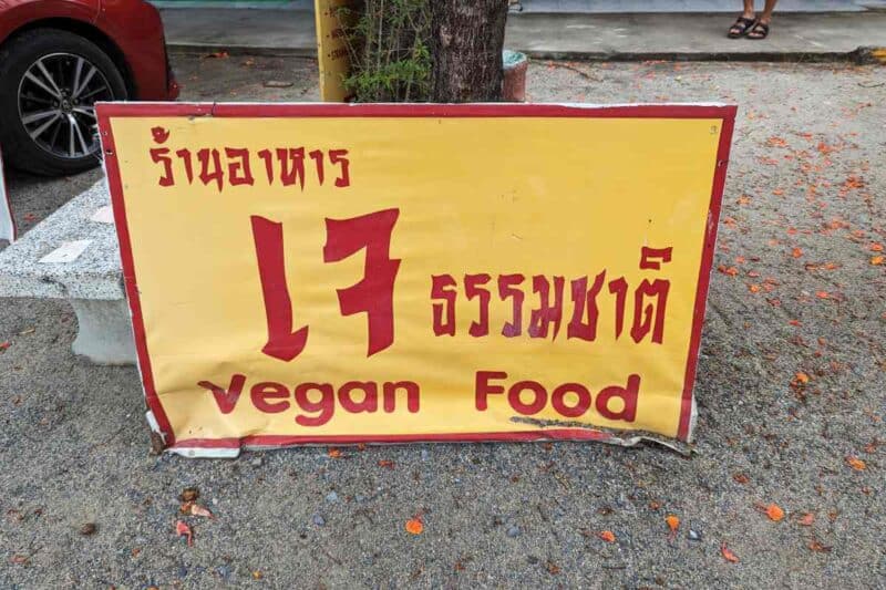 Schild mit dem Thai-Zeichen für veganes Essen