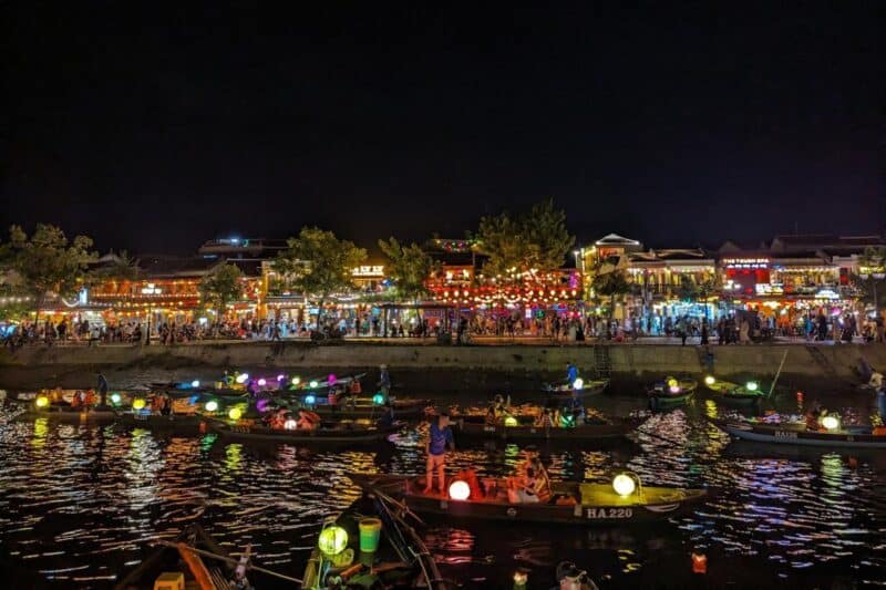 Nächtliches Lichtermeer in Hoi An mit Lampions an den Gebäuden und auf Booten im Fluss