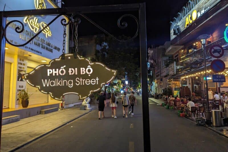 Schild mit der Aufschrift "Walking Street" sowie Bars und Restaurants im Hintergrund
