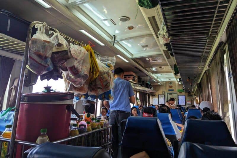 Servierwagen mit verschiedenen abgepackten Speisen in einem Zugwaggon in Vietnam