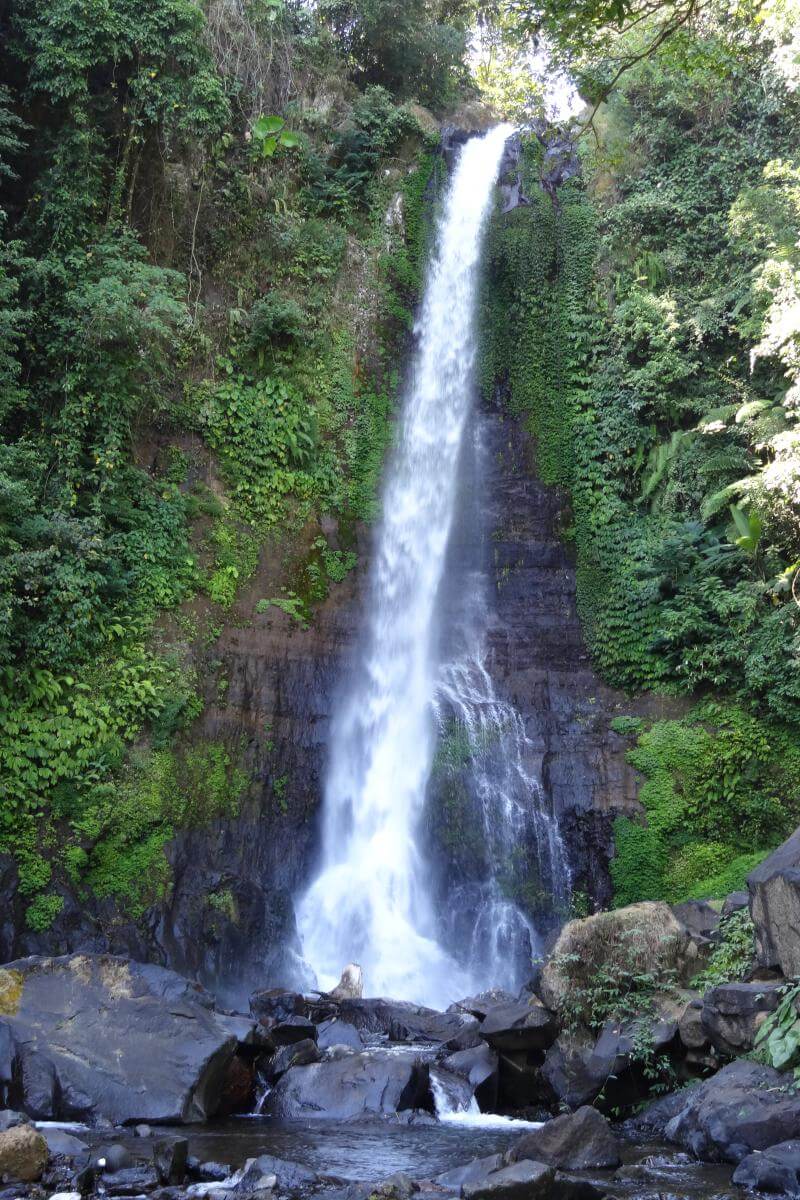 Der 40 Meter hohe Gitgit-Wasserfall, umgeben von üppiger tropischer Vegetation