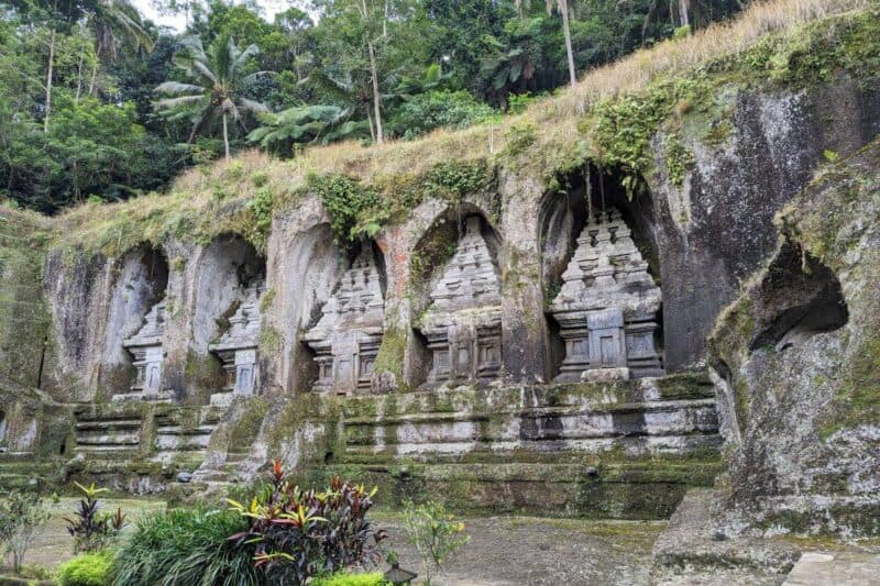 Riesige Felsskulpturen in Form von Sarkophagen in einer Felsmauer in Gunung Kawi