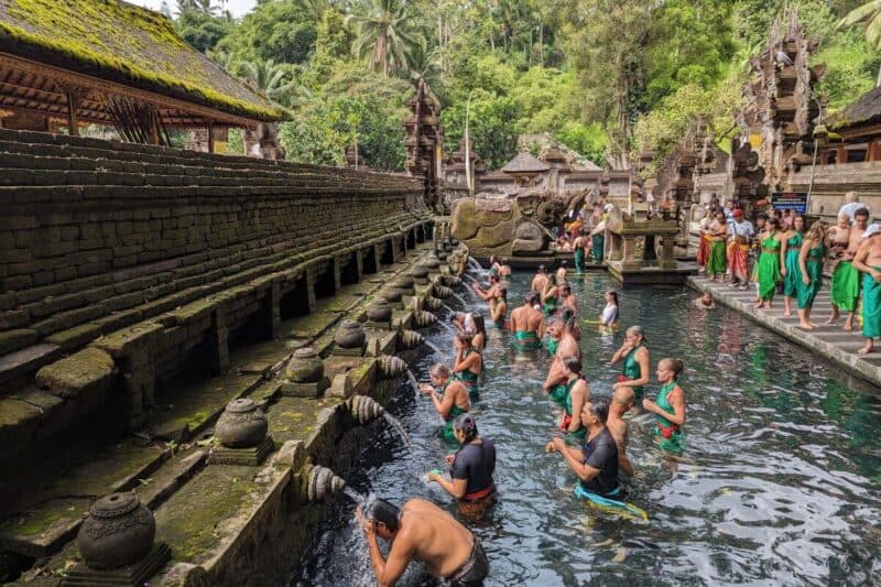 Menschen bei der rituellen Waschung im Badebecken des Pura Tirta Empul auf Bali