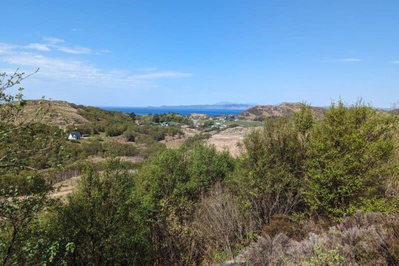 Hügelige Landschaft neben der Road to the Isles mit blauem Meer im Hintergrund